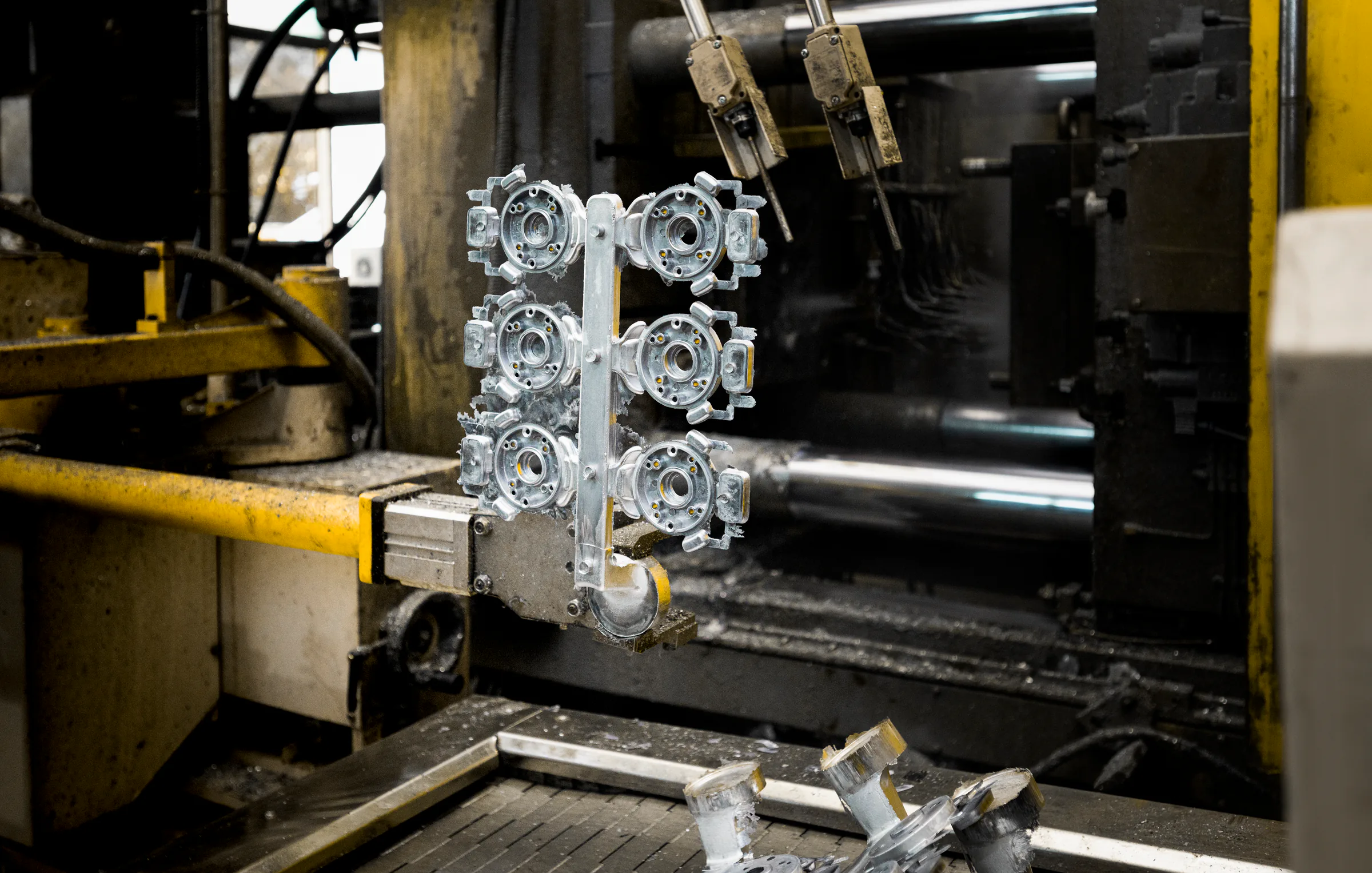 Fresh die-cast metal parts on a carrier at a production cell